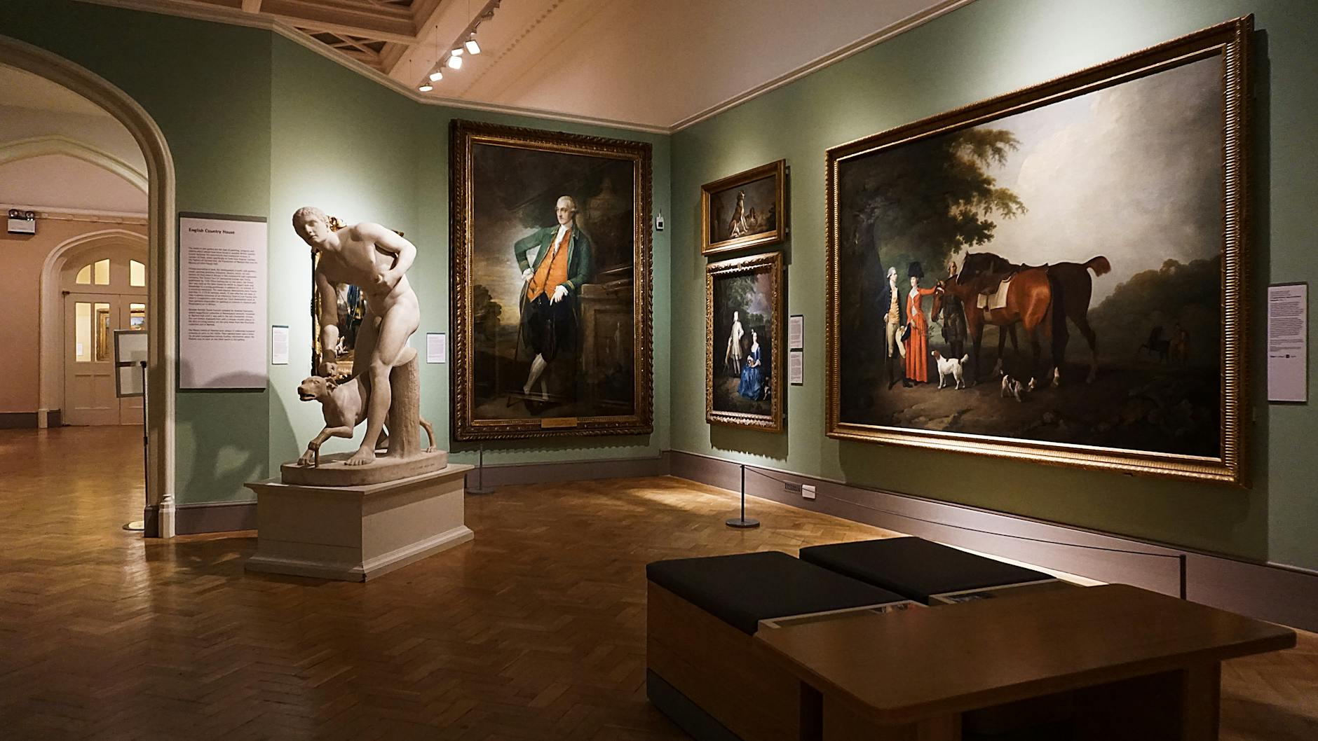 Gallery room with classical paintings and marble sculpture